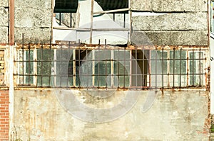 Small house near building with damaged door and walls with bullet holes used as improvised hidden prison with bars on the windows