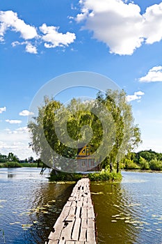 Small house one the island. Landscape with bridge to the house on lake