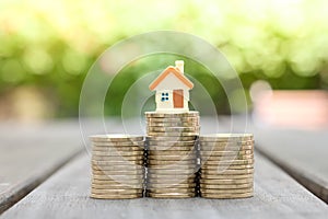 Small house on top of stack of coins. Save money to get property. business and financial banking background.