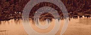 Small houses on the mountain among the forests on the river bank, landscape, reflection in the water, monochrome