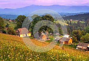 Small houses in mountain village at sunset in summer in Ukraine