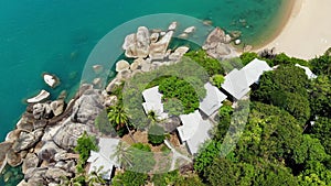 Small houses on tropical island. Tiny cozy bungalows located on shore of Koh Samui Island near calm sea on sunny day in Thailand.