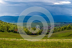 Small , hungarian transylvanian village at sunset with gathering stormclouds