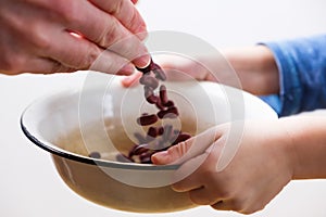 Small hungry child gets food donate help a volunteer, with bowl full of beans