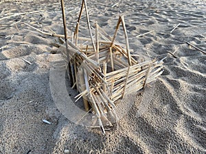 Small hut made of straw on the sand by the sea at sunset
