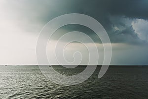 Small hut in the middle of the sea under coming storm.