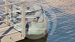 A small, inflatable boat anchored at pier. Rubber boat on water. Fishing theme