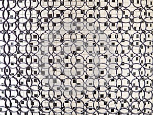 Small interlocking ring loops, with black and white small ceramic tiles in background