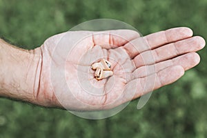 Small intra channel hearing aid device in a man`s hand.
