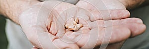 Small intra channel hearing aid device in a man`s hands. banner.