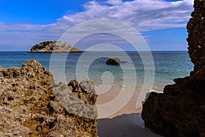 Small island on the beach of Creiro, framed by rocks in the sand, Natural Park of Serra da ArrÃÂ¡bida - SetÃÂºbal, Portugal photo
