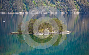 Small island in Norway with mirror reflection at water photo