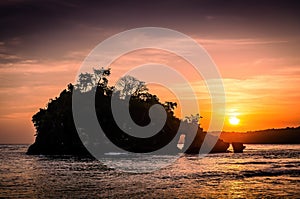Small island in the sea during sunset. Sunset over the ocean on a tropical island. Nusa Penida, Crystal bay beach, Bali