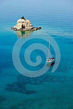 Small island solitary and sailing boat photo