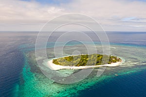 A small island surrounded by azure water and coral reefs, a top view