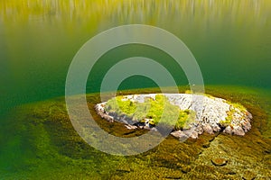 Small island in very clean water of a glacier lake