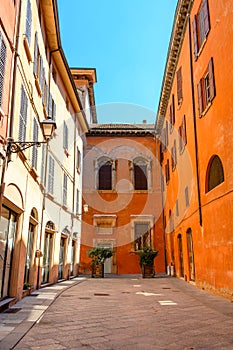 Small Italian rectangular yard with colorful house facades, with blue sky