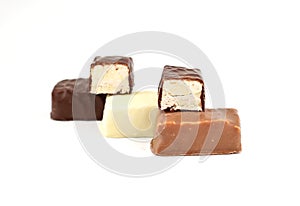 Small italian Torrone, or nougats, covered with milk, dark and white chocolate