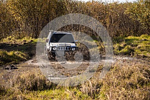 Small japanese suv overcomes water obstacle photo