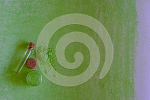 small jars with green chalk, on a green sheet of paper