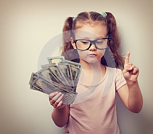 Small kid girl holding dollars and have an plan how earning much