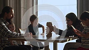 Small Kids Children playing tiny jenga with her parents at table, jenga tower falls apart, Family have great time