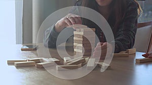 Small Kids Children playing tiny jenga with her parents at table, jenga tower falls apart, Family have great time