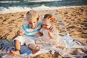 Small kids are playing and having fun at beach together near the ocean, happy lifestyle family concept