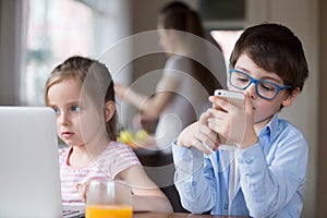 Small kids using gadgets playing games or watching video