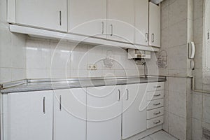 Small kitchen with white cabinet doors and drawers with a hidden