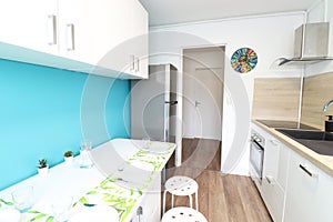 Small kitchen with white table and stool