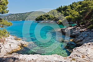 Small lagoon with pine trees and rocks over crystal clear turquoise water near Cape Amarandos at Skopelos island