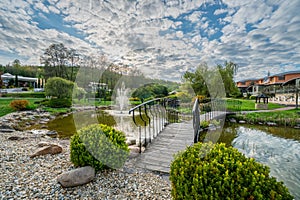 Small lake with fountain and bridge near Kaskady hotel wellness and spa resort building near Sielnica