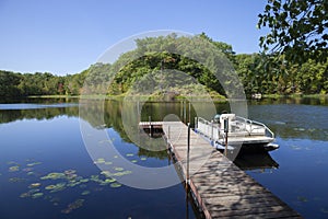 Small lake in northern Minnesota with a dock and pontoon boat