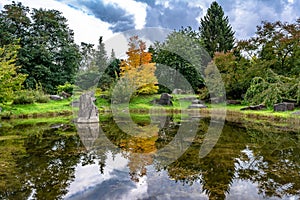 Small lake surrounded by forest with colorful trees at autumn cloudy day in Belgium. Panorama of a gorgeous park in