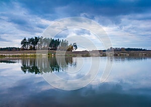 Small lake under dark cloudy sky