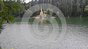 Small lake under a mountain, church in opposite side