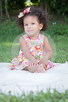 Small latin girl on a green grass park