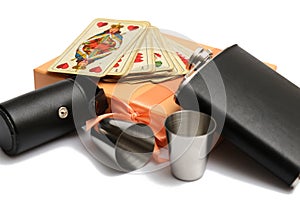 Small leather hip flask with two metal mug and old plauying cards at orange giftbox