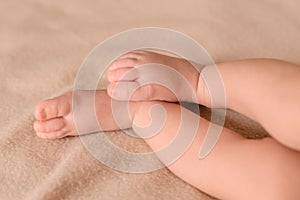 Small legs of a newborn close up. Baby feet on a rug