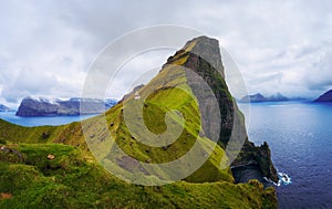 Small lighthouse located near huge cliffs on island of Kalsoy, Faroe Islands