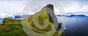 Small lighthouse located near huge cliffs on island of Kalsoy, Faroe Islands