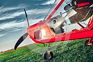 Small lightweight private airplane standing on airfield grass
