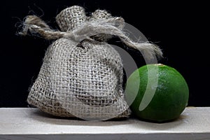 Small linen bag and lemon  on black background