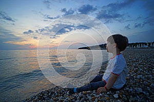 Small little boy watching sunset