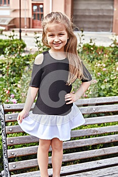 Small little girl play on the yard court stand on the bench