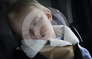 Small little girl toddler sleeping in her car seat.