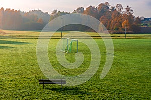 Small, local football pitch.Football gates placed on the grass. Beautiful, foggy, autumn morning in the countryside. Colorful