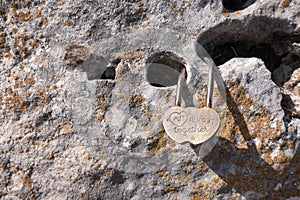 Small lock as symbol of eternal love hangs locked on rock. Details of Spain