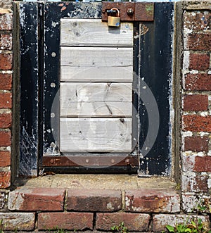 Small locked gate in a brick wall